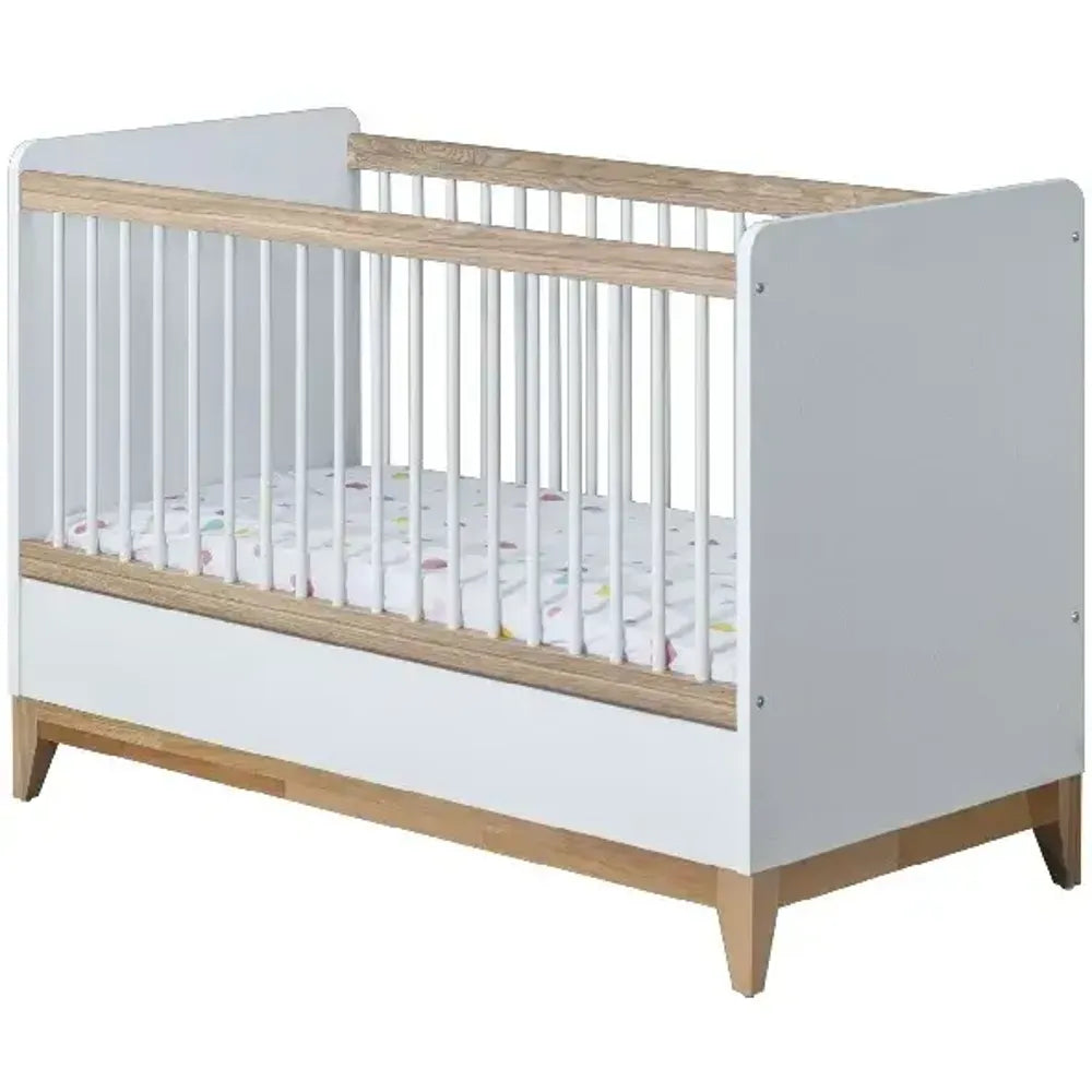 Bonita Crib by Lynda Kids with white and light wood finish, vertical slats, and patterned mattress