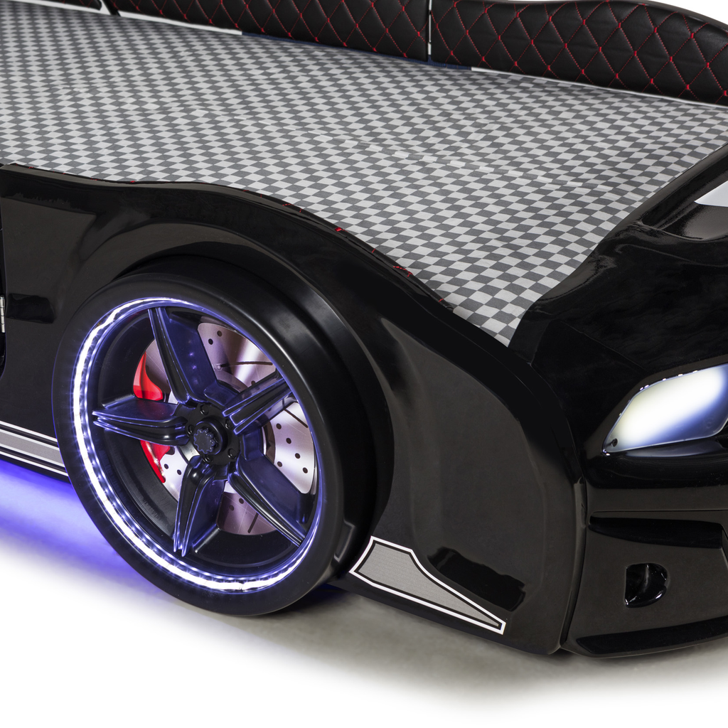 Black muscle racer car bed for kids with glowing wheels and checkered flag mattress